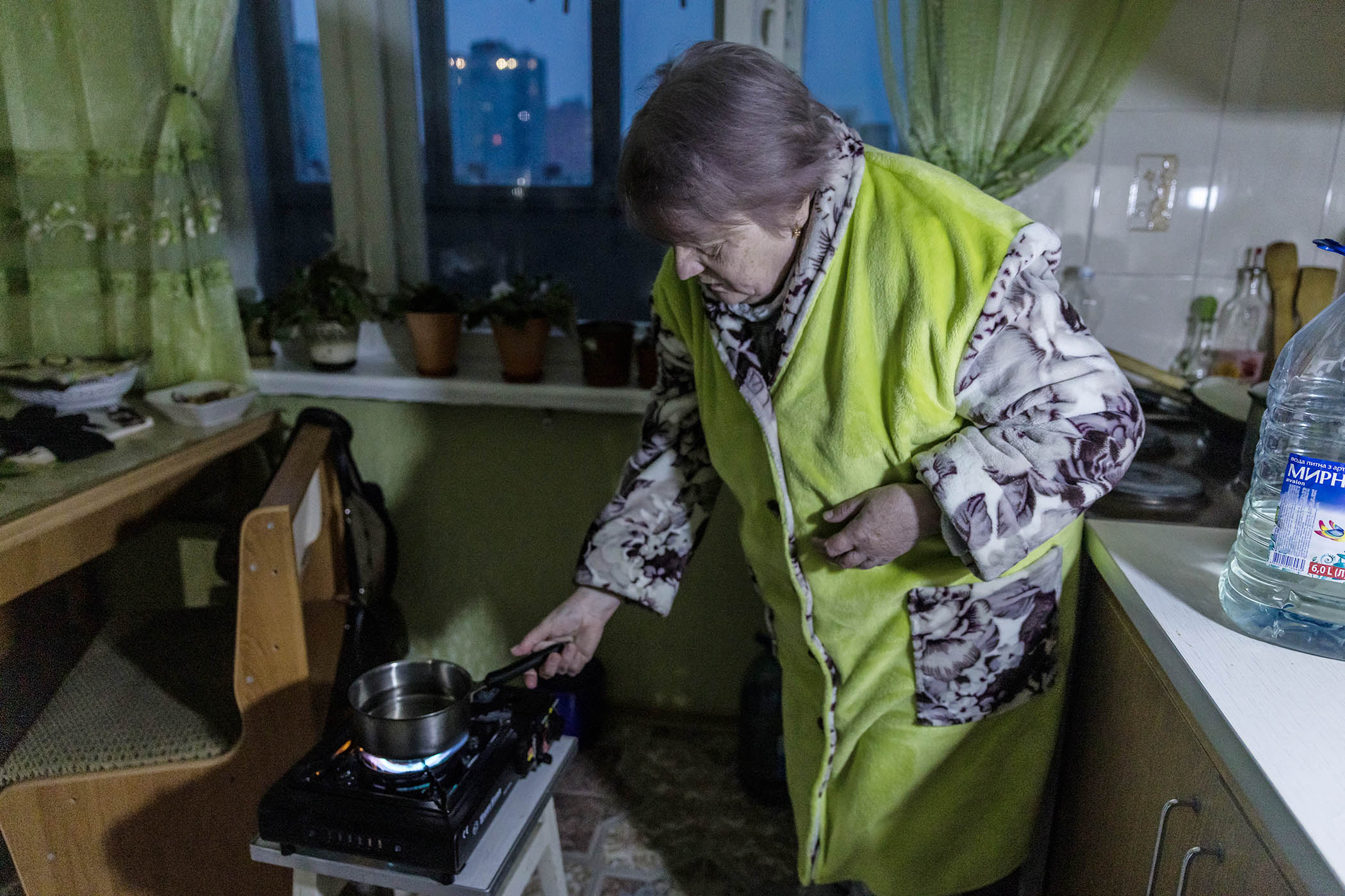 Neonila Fesenko, 68, heats water on a gas stove she received from social services