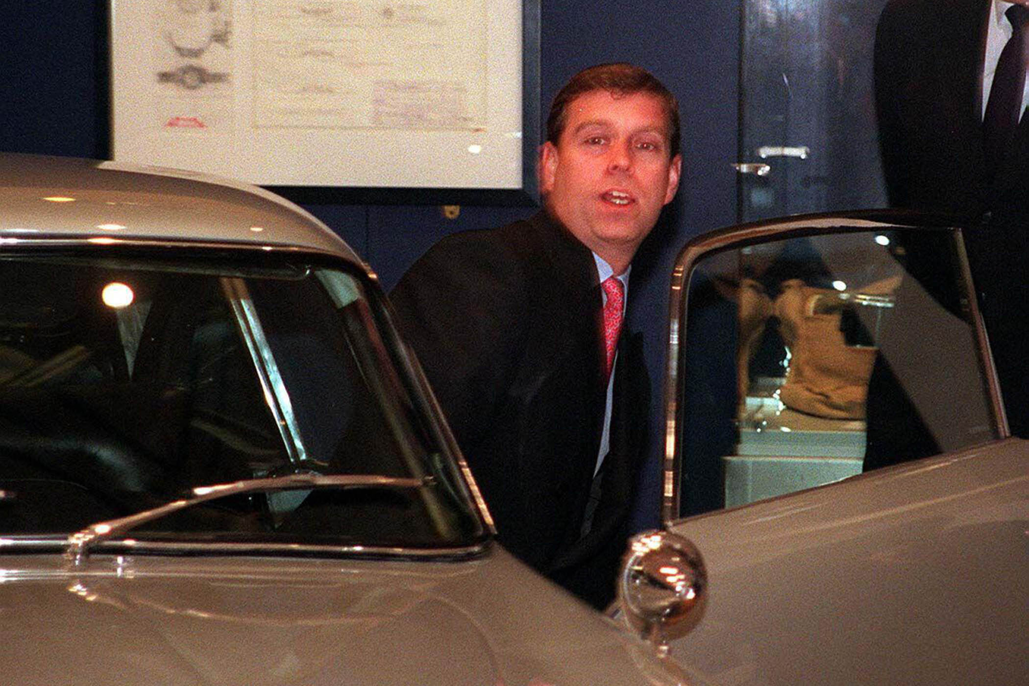 The car-mad former prince climbs into a gold Aston Martin DB6 at a James Bond exhibition in Leeds, 1997