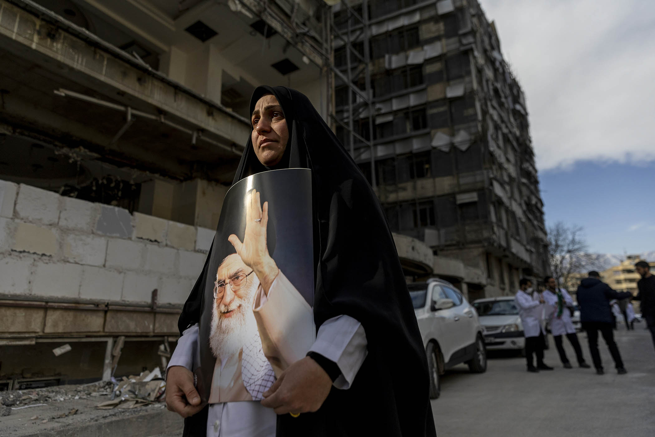 A women holds a portrait of the late Ayatollah Ali Khamenei at a protest by medical professionals outside Tehran’s Gandhi Hospital, which was damaged in an airstrike