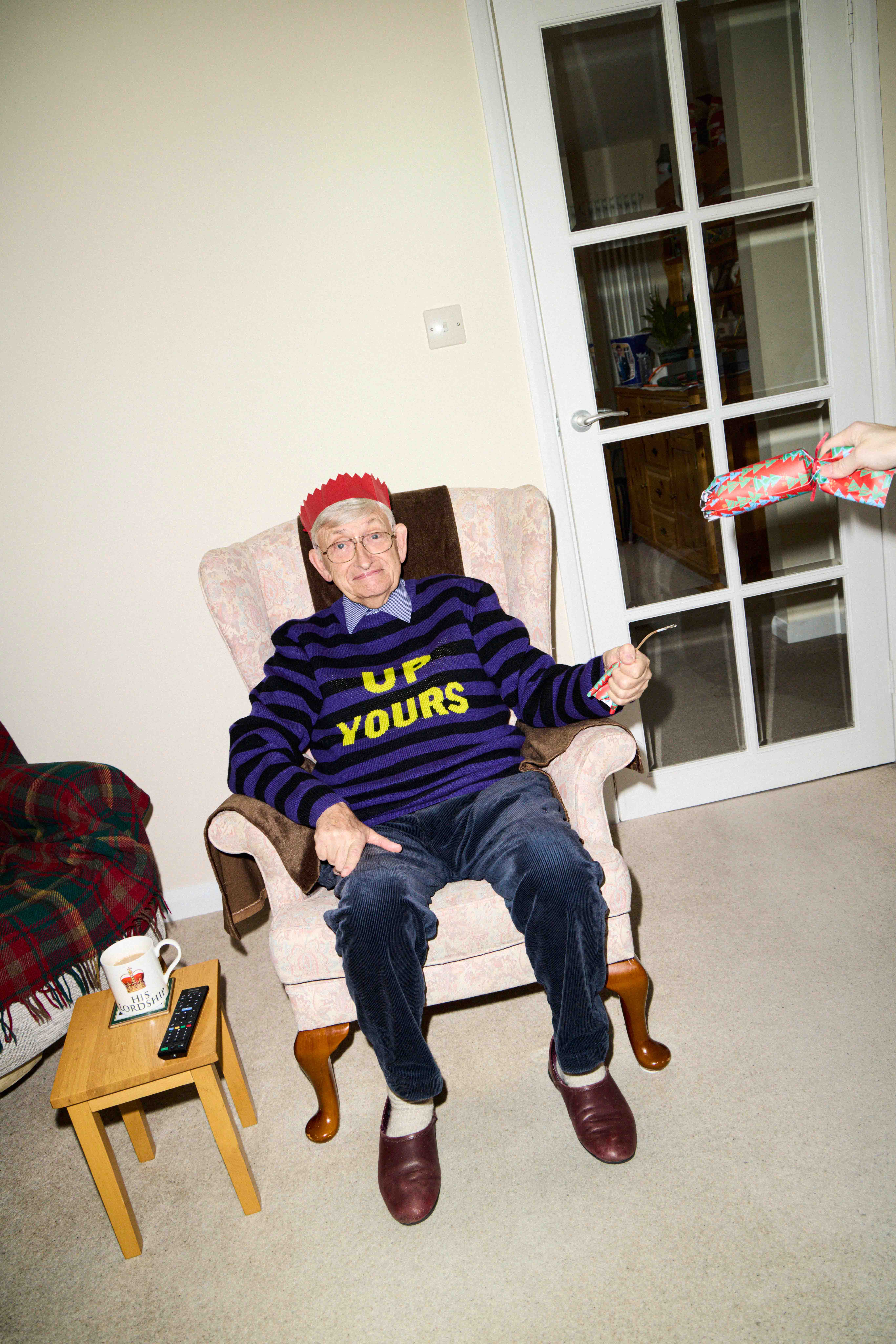 Michael wears Up Yours jumper, £450, by Ashish; corduroy trousers, £89, and Christmas cracker (from a set), £16, both from John Lewis; and leather slippers, £50, Clarks