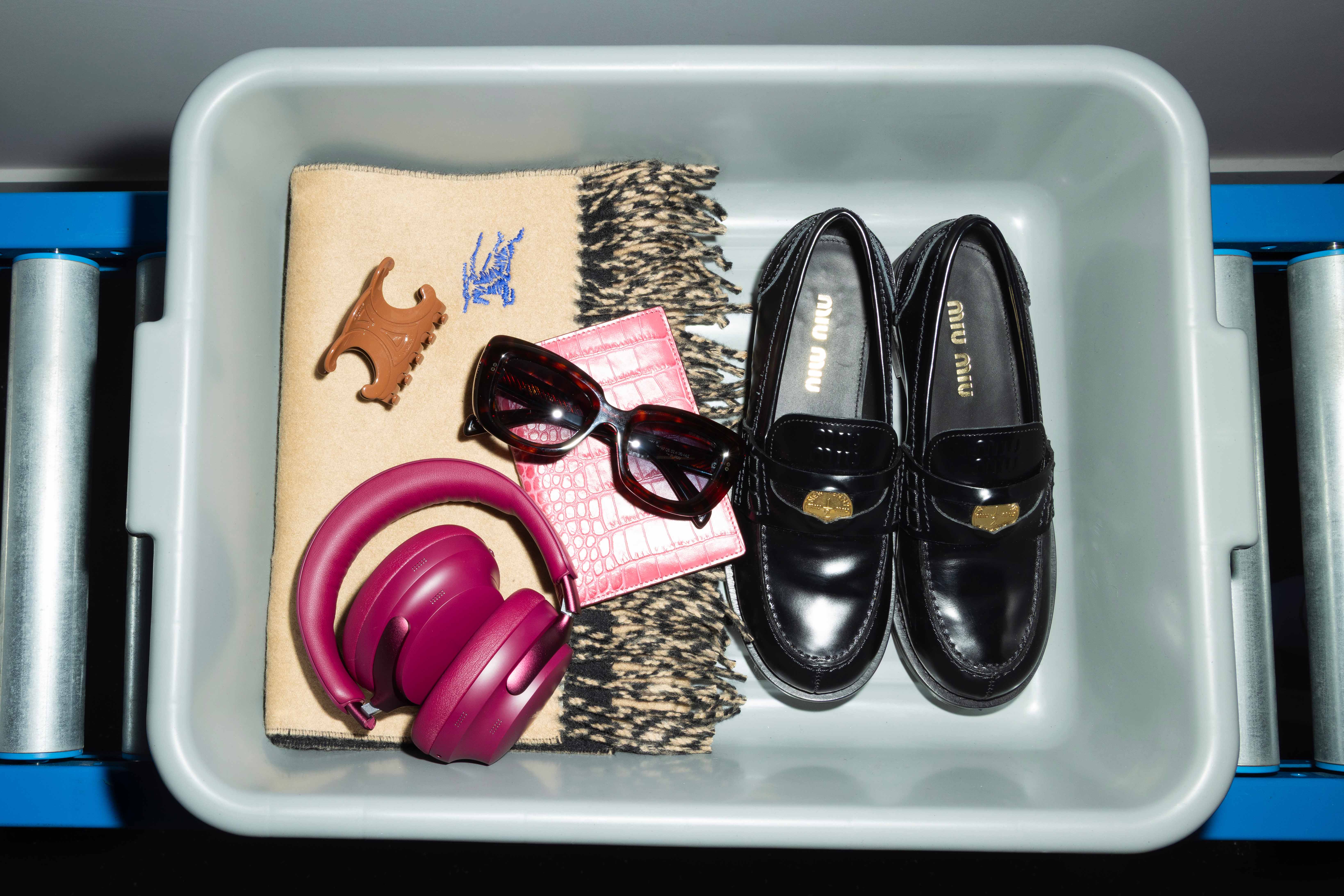 Brushed leather penny loafers by Miu Miu; scarf by Burberry; hair claw by Celine; passport cover by Smythson; and noise cancelling headphone by Bose 