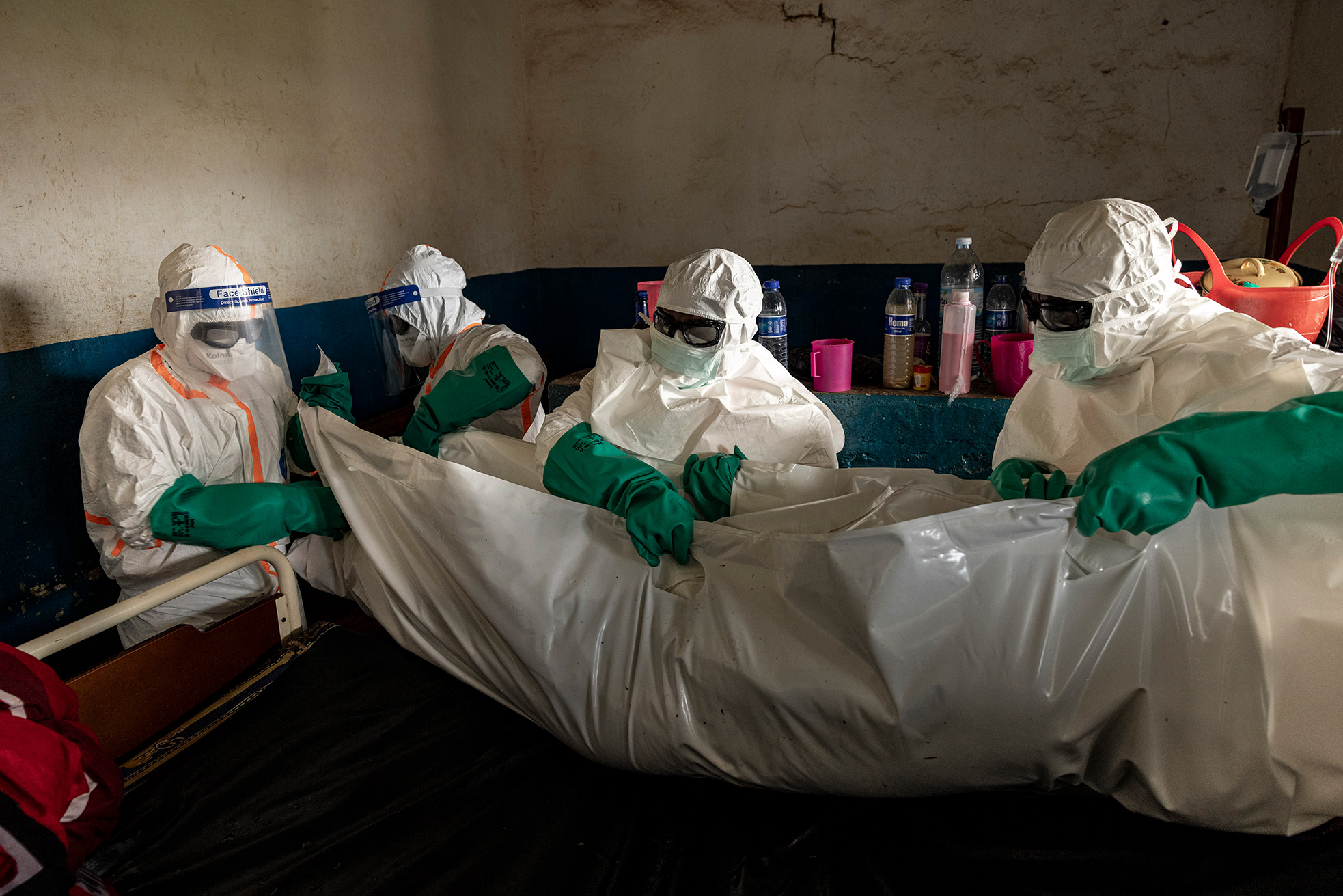 Workers in protective equipment move the body of someone believed to have died of Ebola at the General Referral Hospital of Mongbwalu, DRC