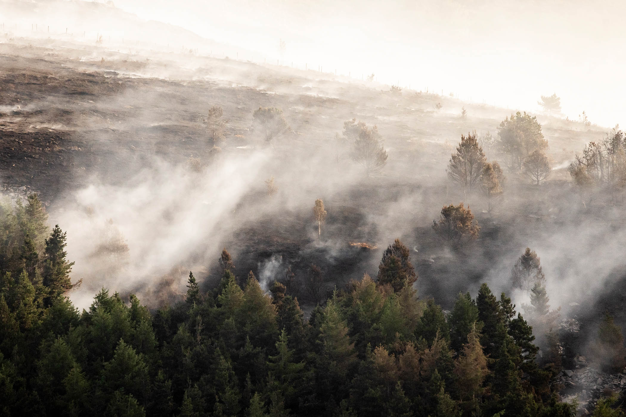 The smouldering remains of a wildfire at Tintwistle Moor in Glossop, England