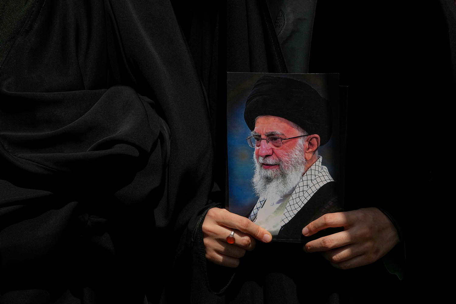 An Iranian holds a poster of the Ayatollah Ali Khamenei during a protest to condemn Israeli attacks on cities across Iran