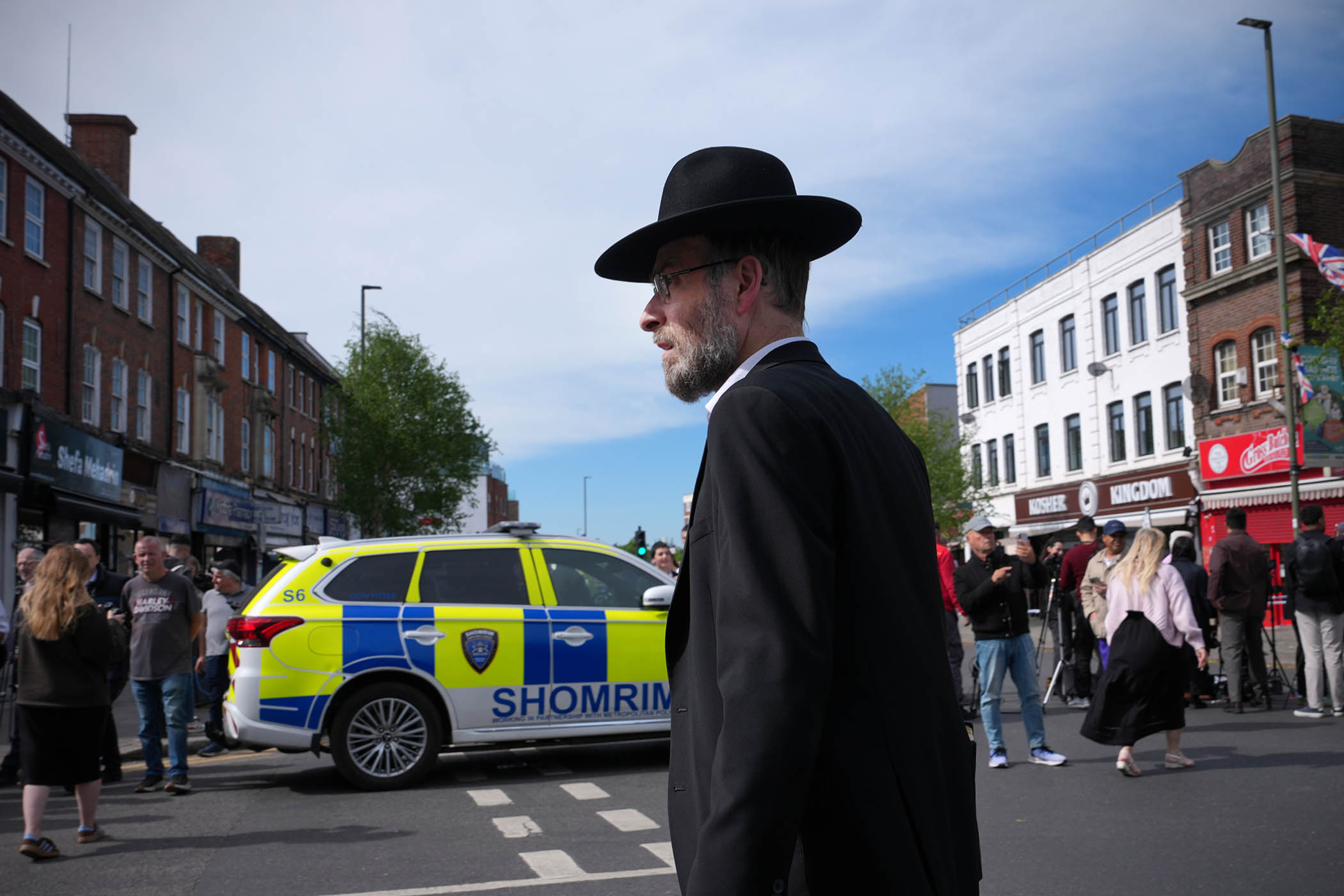 People gather at a road block after two people were stabbed in Golders Green