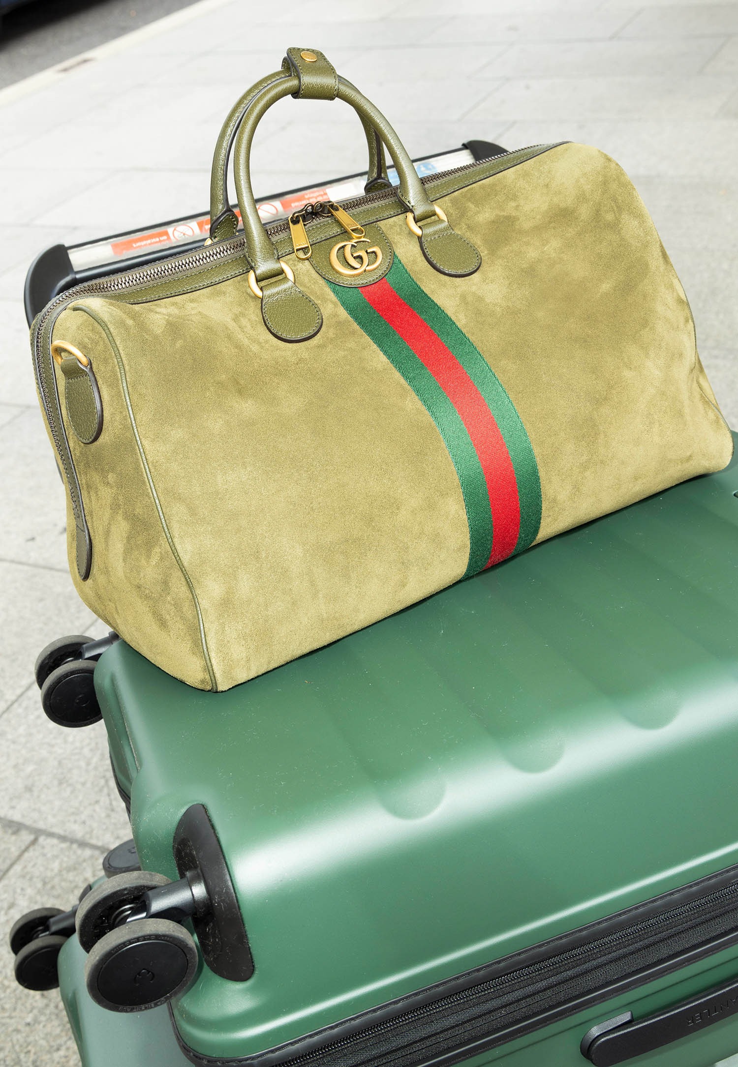 Ophelia duffle bag by Gucci; green suitcase set by Antler