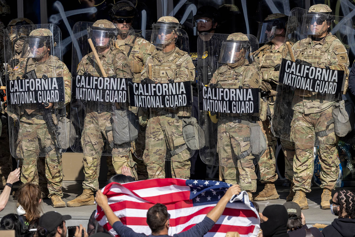 Protesters confront national guard troops and police outside a federal building in Los Angeles