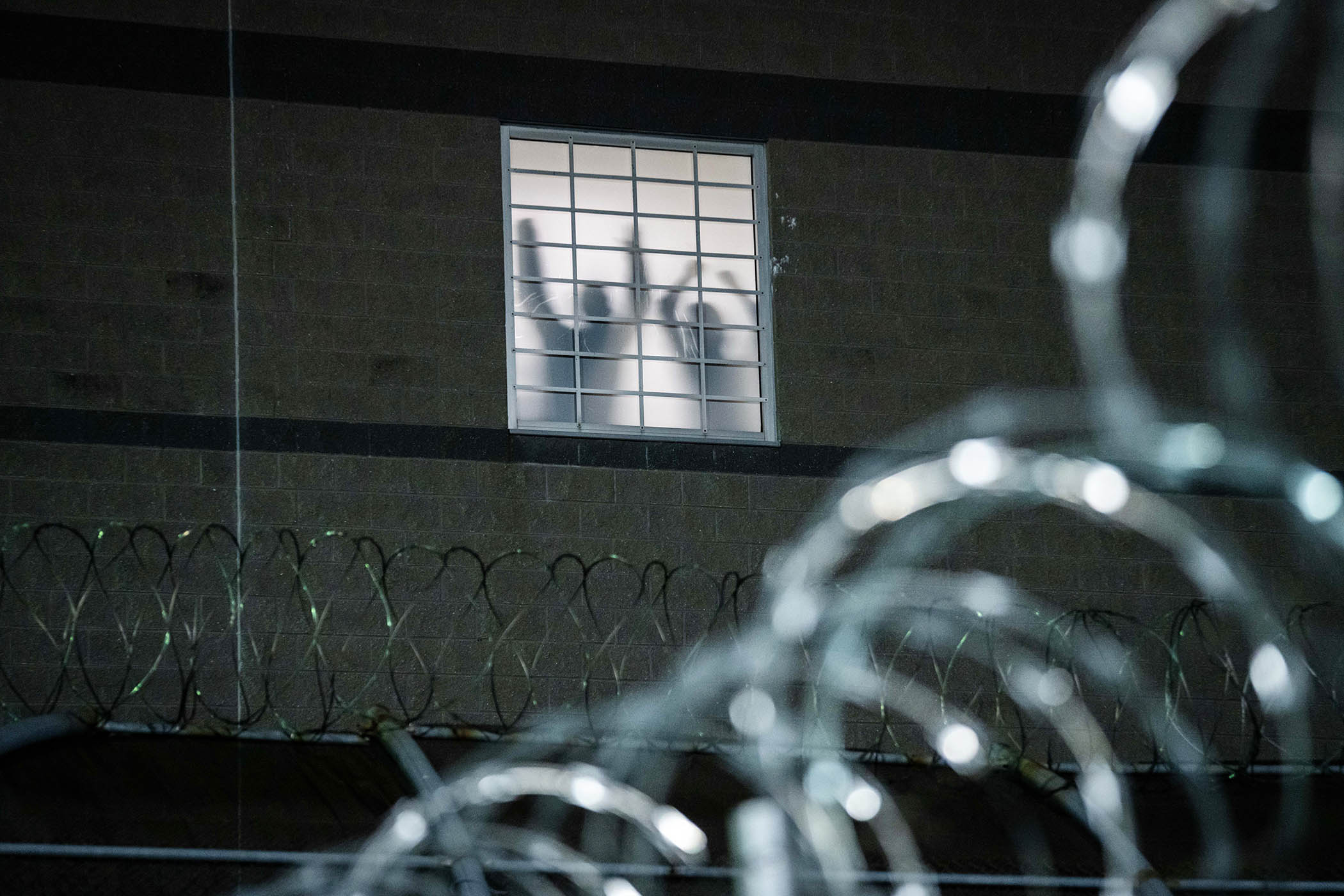 Detainees stand by a window inside the federal immigration center at Delaney Hall in Newark