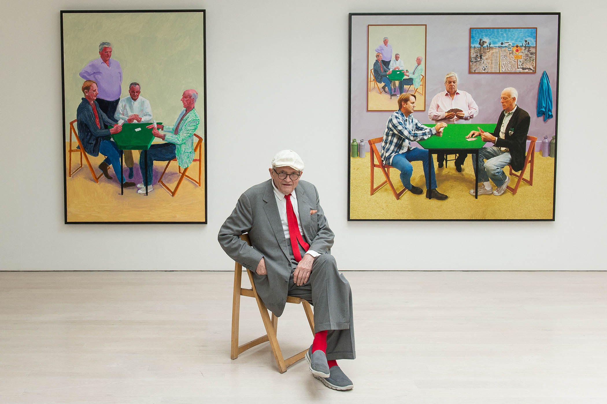 David Hockney with his artworks “Card Players #3 2014” (L) and “A Bigger Card Players 2015” at his exhibition entitled “Painting and Photography” in London, 2015