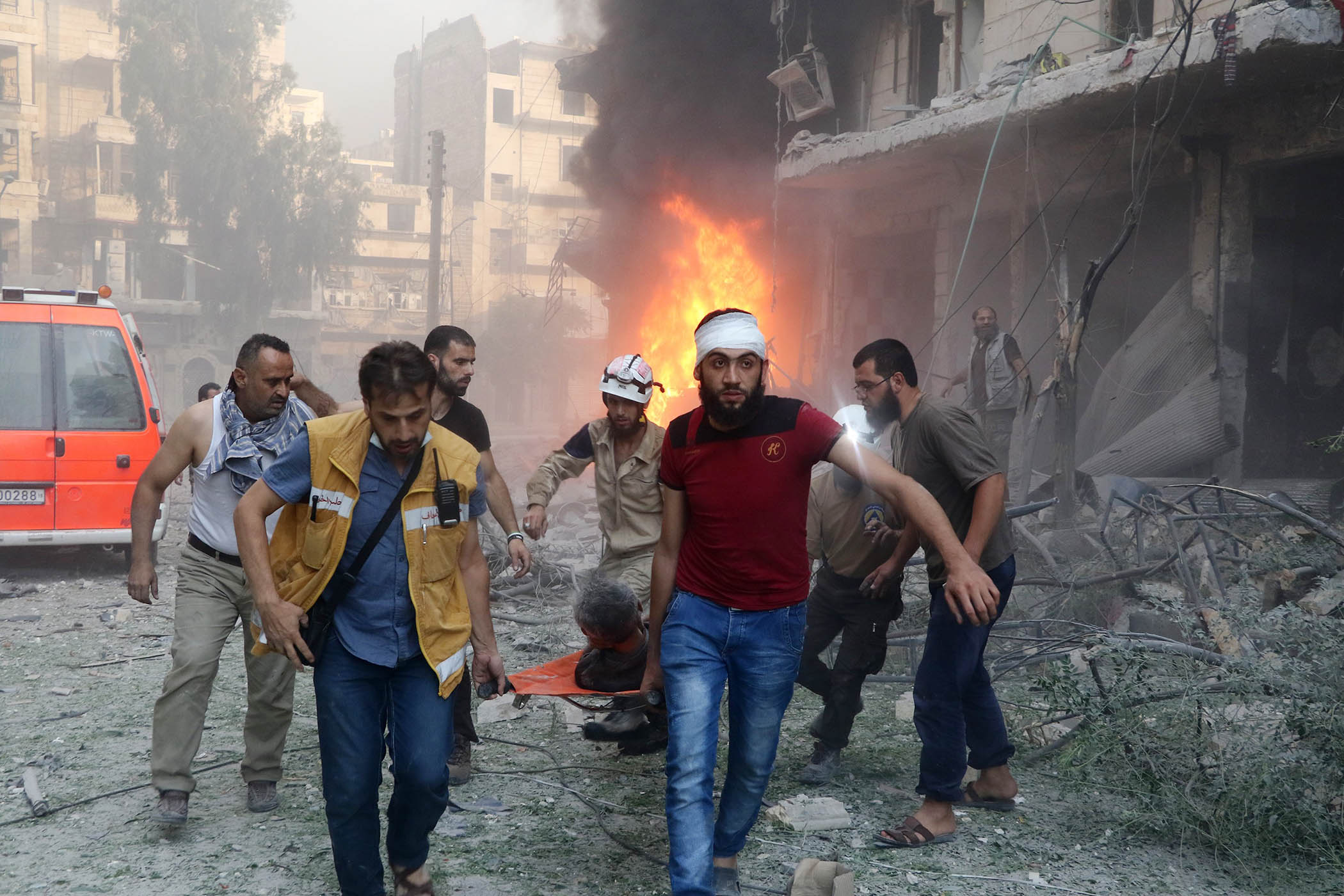 Civilians carry an injured victim after Assad’s forces hit residential areas in Aleppo in 2016.