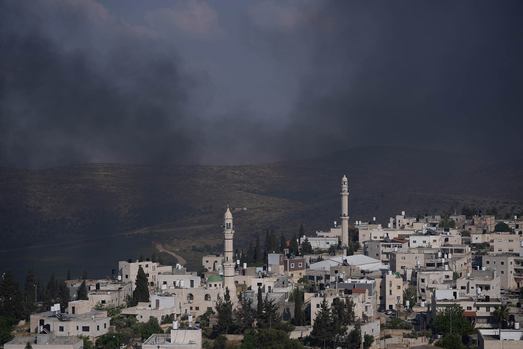 Smoke fills the sky after Israeli settlers set fire to the properties of Palestinian villagers in the West Bank village of al-Mughayyir, Saturday, April 13, 2024