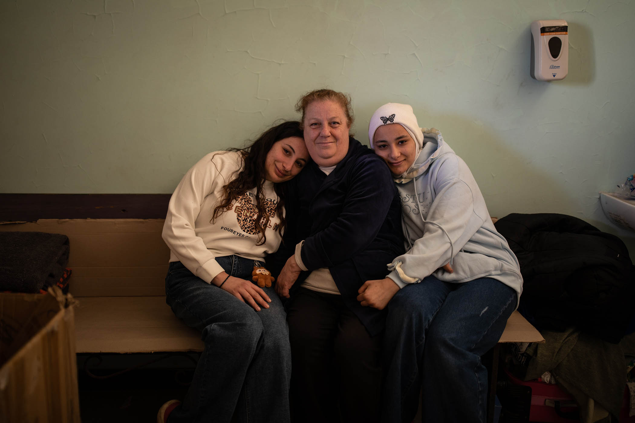 Fatima Daoud, 52, sits in the security guard’s room, with her two daughters Zeinab, 24, (left) and Reem, 20, (right) in the Sobhi Al Mahmasani High School which she nows calls home after being displaced from her home in the Dahiyeh.