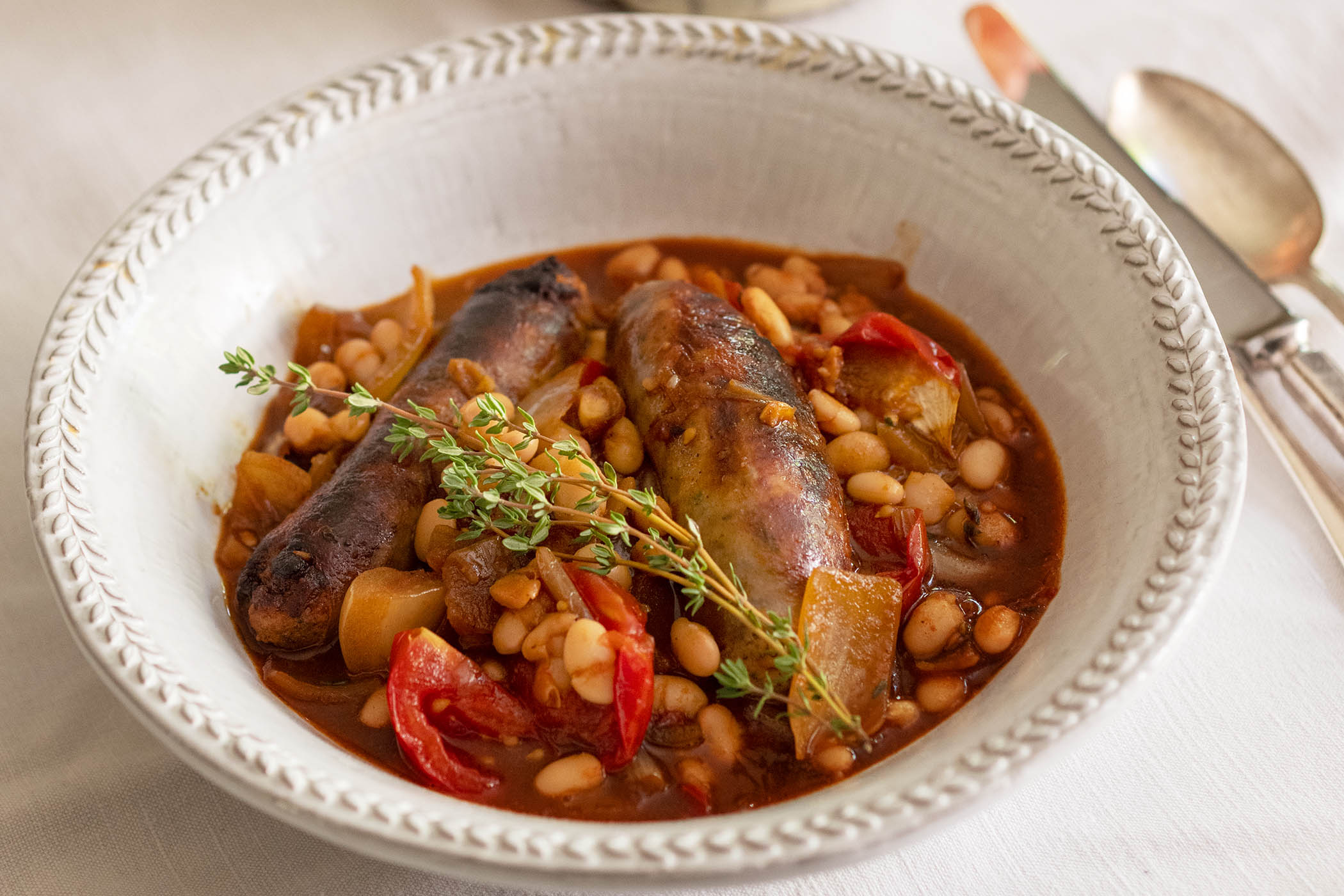 Nigel Slater’s recipe for sausages, haricot beans, tomato