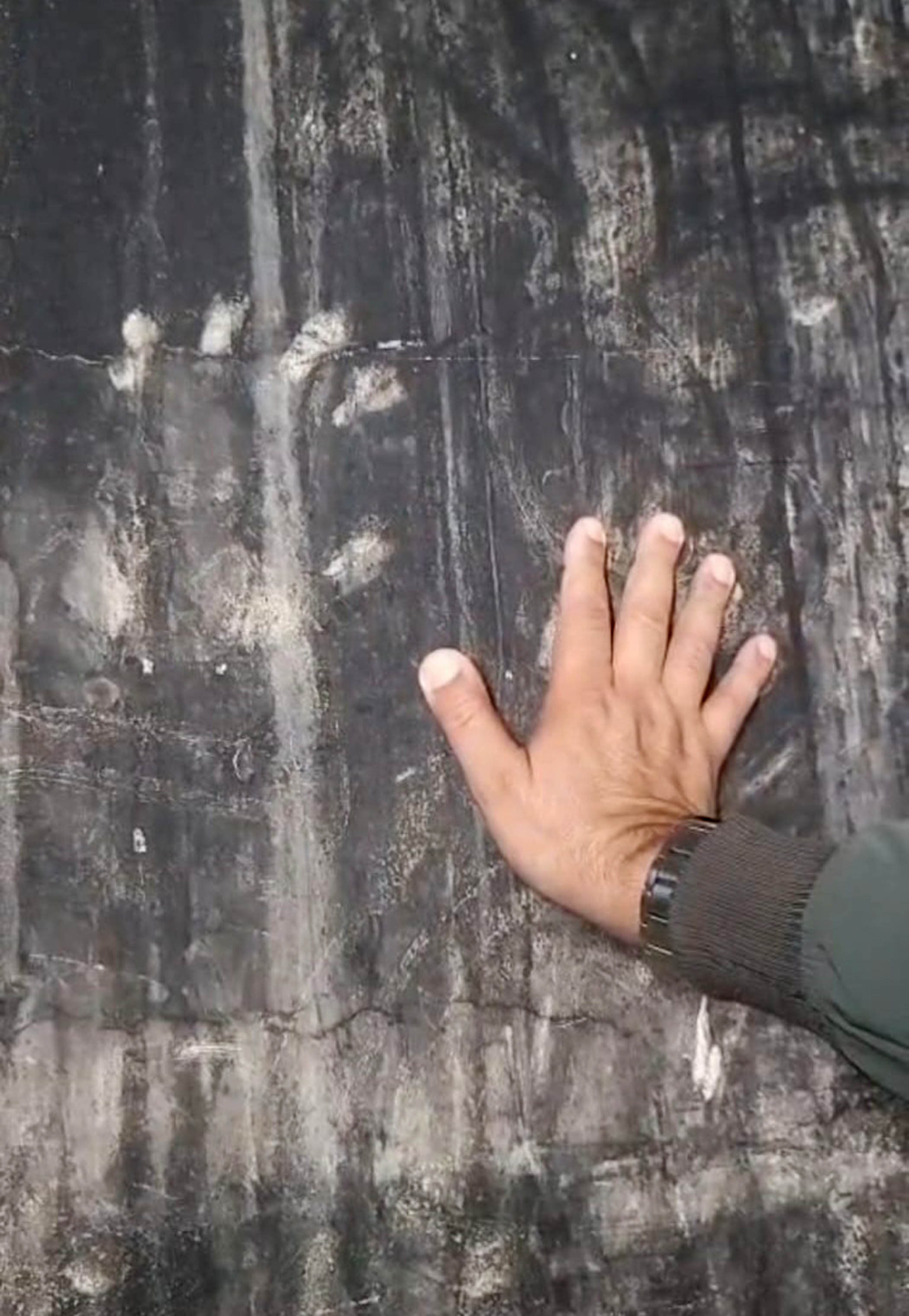 Karim with one hand on top of the handprint