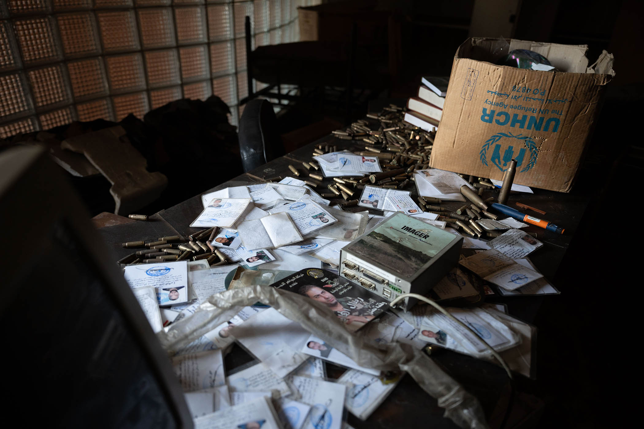 Government documents and shell casings litter an abandoned Syrian Air Force intelligence base.