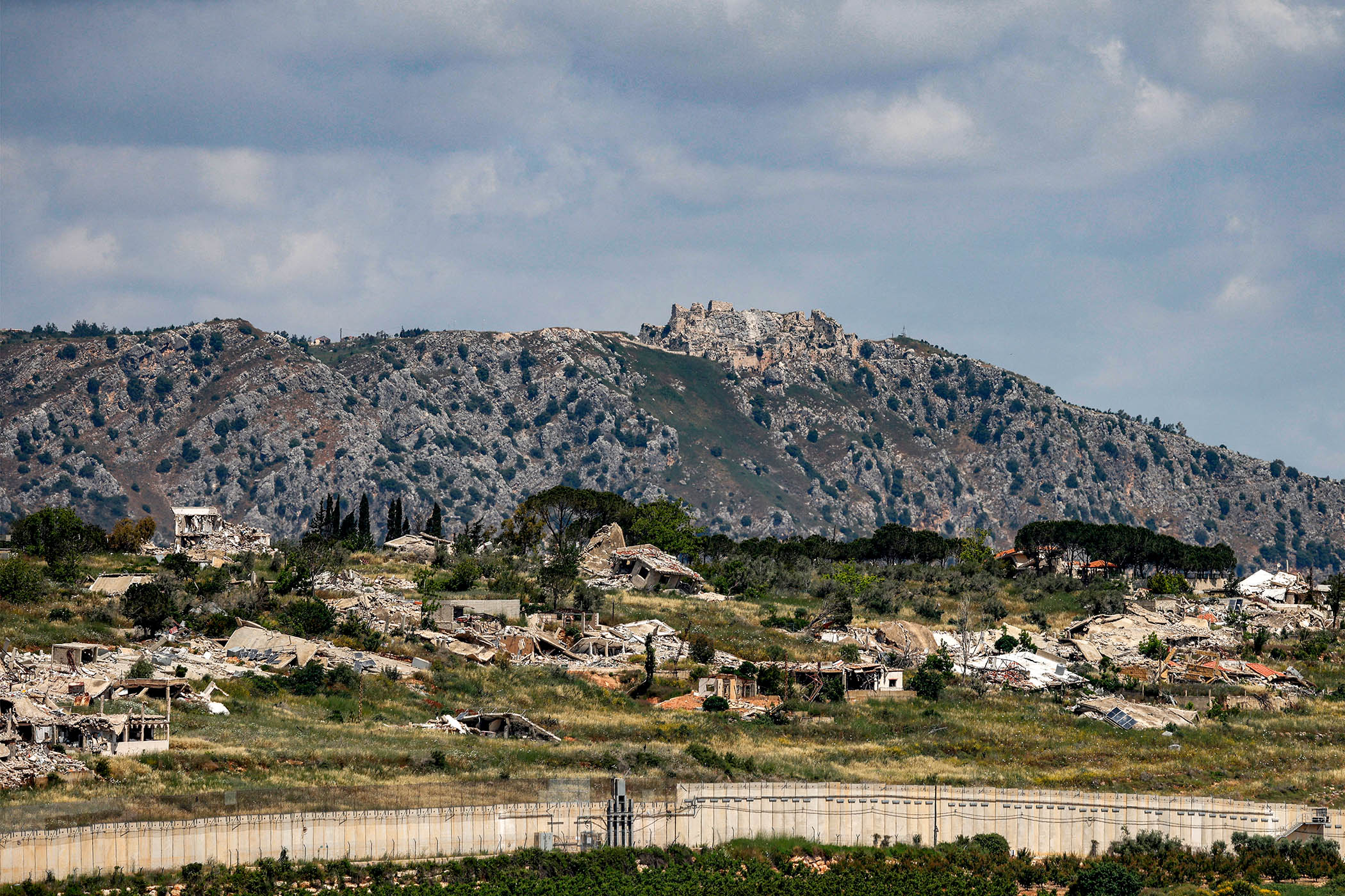 Destroyed buildings in the Lebanese village of KfarKila, with the 900-year-old Beaufort Castle in the background