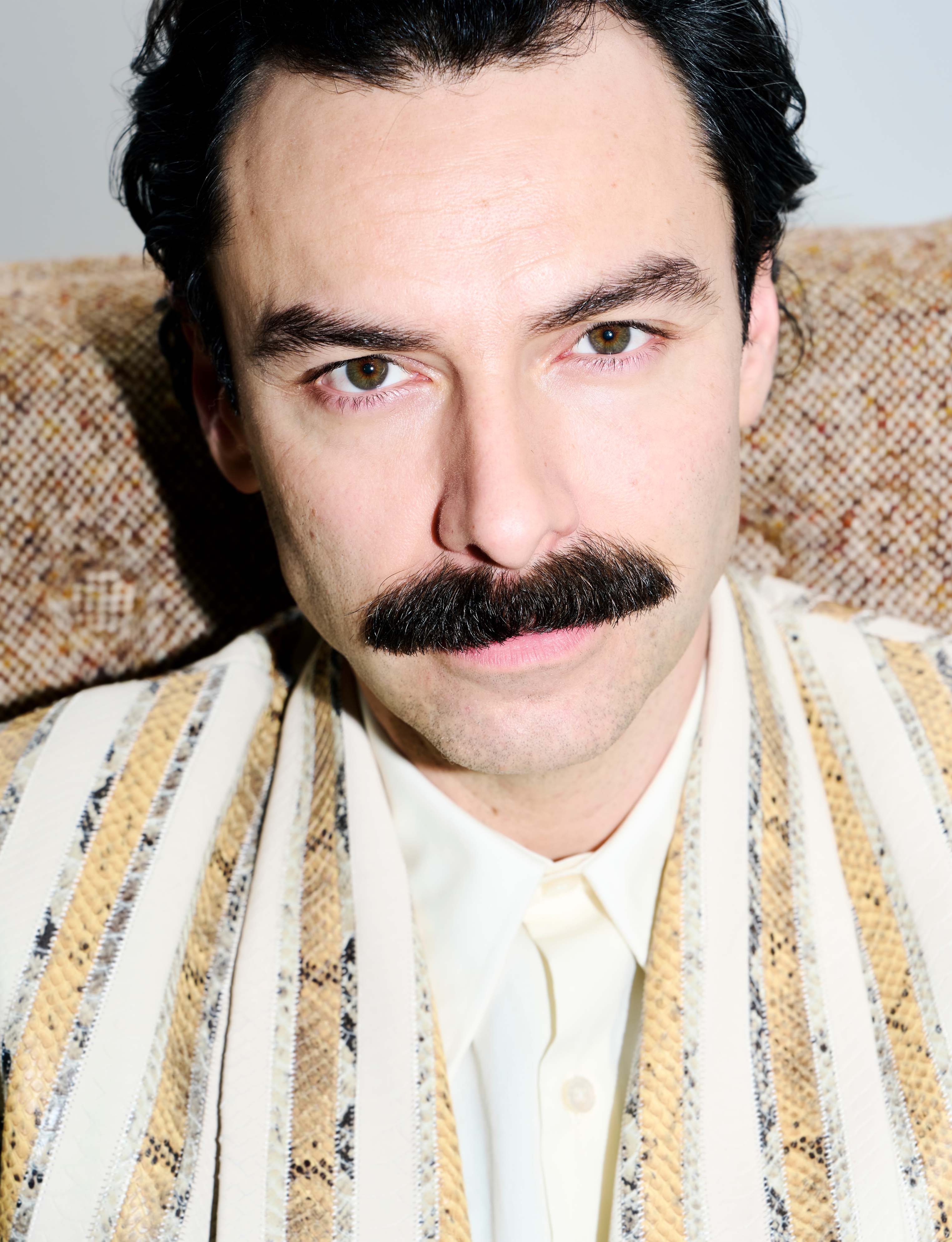 Aidan Turner wears jacket and shirt by Amiri